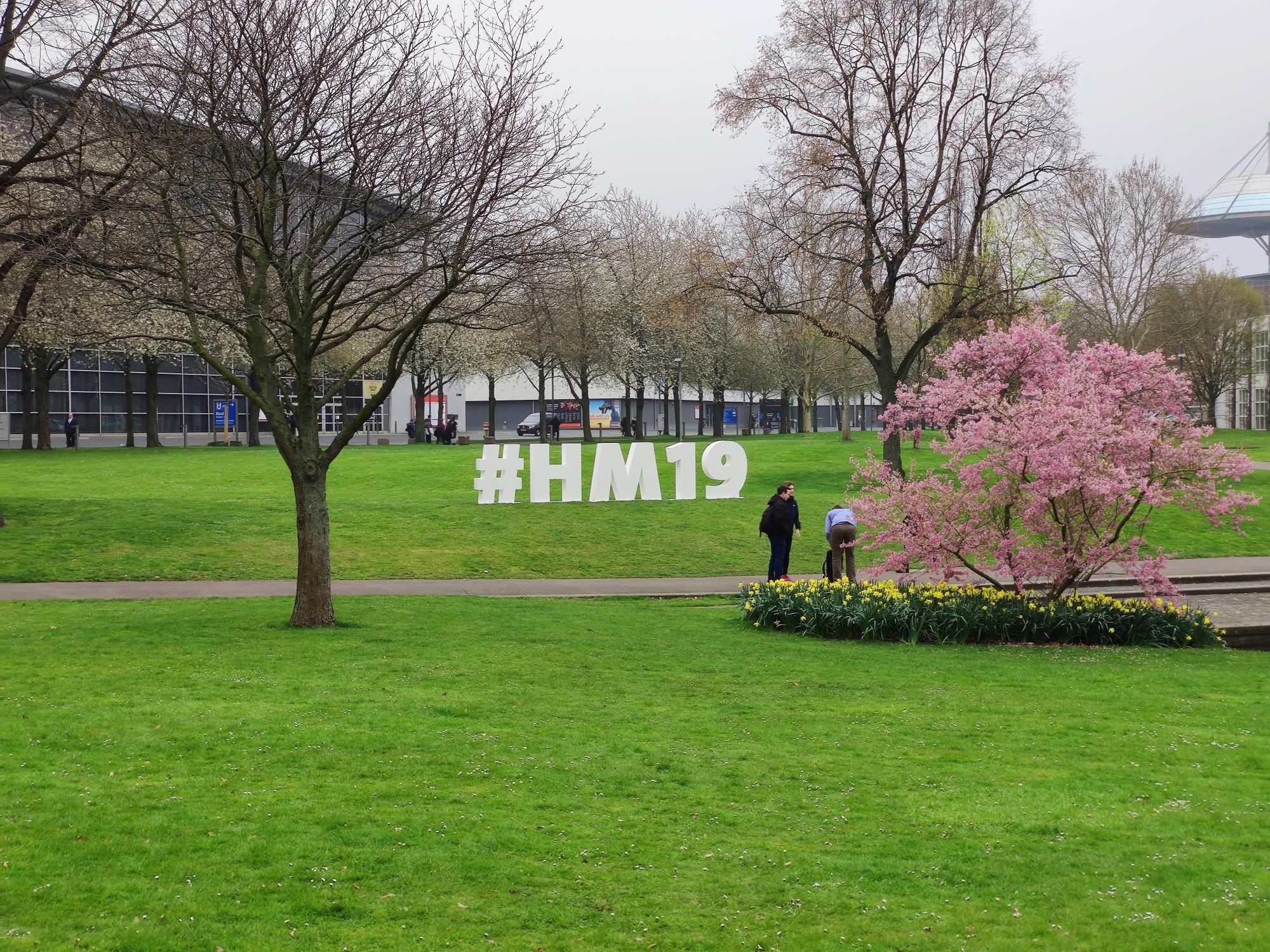 Dieses Bild zeigt einen physischen #HM19-Hashtag auf der Wiese vor Halle 2.